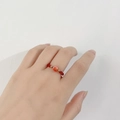 Nahaufnahme eines handgefertigten Perlenrings mit rotem Herzkristall und goldenen Perlen - Stil A - Einzelnes Herz