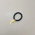 Detalle de anillo elástico con cuentas negras facetadas y colgante de luna dorada - Colgante de Luna / Cuenta Negra