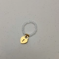 Detail van elastische kralenring met kristallen en een gouden hartvormige slot hanger - Slothanger / Transparante Kralen