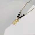 Detailansicht des 18K Gold Evil Eye Anhängers mit Himmelskörpern wie Mond und Sternen - Schwarzer Perlenstil