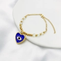 Détail du pendentif cœur œil protecteur doré avec chaîne perlée et fermoir mousqueton - Bleu