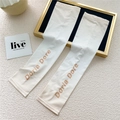 Detail view of off-white ice silk cooling sleeves with elegant Doria Dore lettering - One Size / Gradient Beige