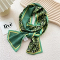 Emerald green silk scarf with ginkgo leaf pattern and yellow trim on display - Green Reed Print