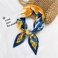 Pleated square silk scarf in yellow and blue floral print tied on a summer straw bag - Surfing Orange