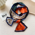 Elegant orange and dark green floral silk skinny scarf with satin finish on wooden board - Diagonal Red Branch