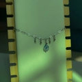Détail d'une chaîne argentée bohème avec pendentif en pierre de marbre bleu sur bois - Goutte de Pierre Bleu Blanc - Couleur Acier