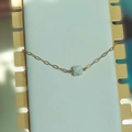 Détail d'un bracelet en chaîne dorée avec une pierre bleu clair carrée sur un présentoir - Turquoise Blanche - Or