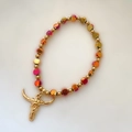 Detailed close-up of beaded bracelet with colorful iridescent beads and bull head charm - Iridescent