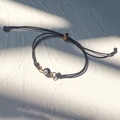 Dettaglio del bracciale regolabile in corda nera intrecciata con perla malocchio oro - Oro-Corda Nera