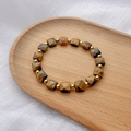 Macro shot of faceted square tiger eye stones with gold spacer beads on a wooden tray - Square Style (DB058-D)