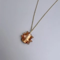 Macro detail of amber glass pendant with gold foil on a minimalist gold chain - Gold-Amber