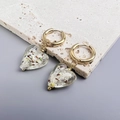 Detalle macro de pendientes de corazón dorados con pan de oro y cristal de colores - Oro-Blanco