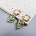 Primer plano de pendientes de corazón verde con pan de oro e inserciones metálicas doradas - Dorado-Verde Claro
