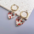 Dettaglio di orecchino a cerchio dorato con pendente a cuore in vetro e punti rossi - Oro-Rosso Trasparente (Pois Decorativi)