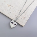 Detailed view of 3D heart-shaped glass pendant with abstract spots and silver link chain - Steel White Texture