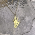 Detail showing an 18K gold Hamsa Hand pendant with hollow heart and eye engravings - Hamsa Hand Heart Star Style (DN192-171)