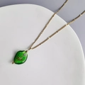 Detalle del colgante de cristal verde en cadena de acero inoxidable chapada en oro 18K - Oro-Verde
