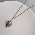 Detalle del colgante de cristal púrpura con motivo floral en cadena de acero dorado de 18K - Dorado-Púrpura