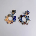 Dettaglio di orecchini a fiore in acrilico con trama marmorizzata blu e arancione - Marrone scuro