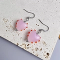Nahaufnahme der rosa Herzohrringe mit roten Perlenakzenten und Silberhaken - Silber-Rosa