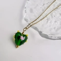 Detailopname van de groene glazen hartvormige ketting met kleurrijke 3D bloemaccenten - Harthanger (Gouden Ketting) / Goud-Groen