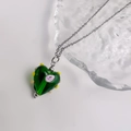 Detail van groene hartvormige glazen hanger met roze bloemen op een zilveren ketting - Harthanger (Zilveren Ketting) / Zilver-Groen