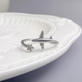 Détail macro d'une bague avion et étoile avec zircons posée sur céramique blanche - Style d'Avion Étoile (WR037)