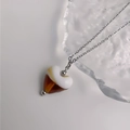 Détail du collier cœur avec pendentif en résine ivoire et ambre sur chaîne argentée - Acier-Café