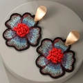 Macro detail van handgemaakte bloemenoorbellen met blauw borduurwerk en rode kralen - Rood (M171)