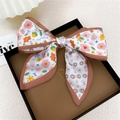 Barrette nœud en satin à motif floral rose et jaune sur un coffret cadeau marron - Fleur Dessin Animé