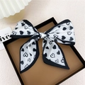 Foulard chic en soie à motif cœurs noir et blanc noué en nœud sur un plateau - Coeur Noir Blanc