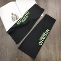 Detail of high-elastic black cooling arm sleeves with green sun protection text print - Black with Green Letter
