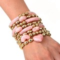 Dettaglio di ciondoli a cuore rosa su un set di bracciali con perline dorate a più strati - Stile Sovrapponibile Rosa Oro (S-295)