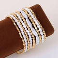 Detail of layered bracelet set featuring faux pearls and golden CCB beads on a brown stand - 9-Piece Set (S-323)