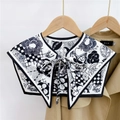Close-up of decorative black and white floral faux collar shawl with tie-bow on a trench coat - Big Flower Small Plaid White (20F)