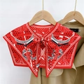 Detail of red printed silk shoulder wrap with equestrian patterns on a khaki trench coat - Star Chain Red (23F)