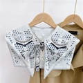 Detail of silk-like shoulder scarf with star patterns knotted over a khaki trench coat - Star Chain Grey (25F)