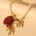 Detailed close-up of crystal flower necklace with pearls and metallic fringe tassels - White Rope Orange Flower