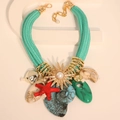 Collier bohème tressé vert menthe avec pendentifs étoile de mer, coquillage et soleil - Collier Seul