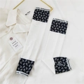 Detail of white cooling arm sleeves with paisley patterns and elastic branded cuffs - Small Paisley Edge