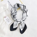 Minimalist square silk scarf with geometric black lines and white base laid on a shirt - Minimalist Line Black Border