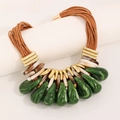 Detail of bohemian multilayer necklace with green resin drops and gold accents - Green