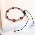 Dettaglio del braccialetto turco Evil Eye intrecciato con perline rosse e cordino nero - Acciaio-Rosso