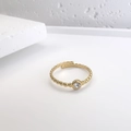 Detail eines vergoldeten Perlenrings mit einem funkelnden zentralen Zirkonia-Stein - Goldener Perlen-Zirkonia-Offener-Stil (DR065)