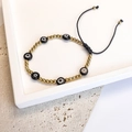 Detail of adjustable evil eye bead bracelet with golden accents on stone base - Gold-Black