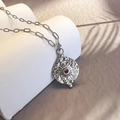 Dettaglio di una collana d'argento vintage con trama a raggiera e ciondolo di zircone rosso - Acciaio-Rosa