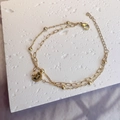 Close-up of double-layered gold bracelet with moon star pendant and lobster clasp - Gold-Moon Star