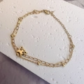 Detail of double-layer gold butterfly bracelet with bead chain and lobster clasp on stone - Gold-Butterfly