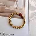 Elastic beaded gold ring with a 3mm natural red stone and polished metal balls - Plain Gold Beads with Single Red Stone Accent