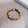 3mm gold beaded stretch ring featuring a green natural stone accent on lilac background - Gold Beaded with Single Unakite
